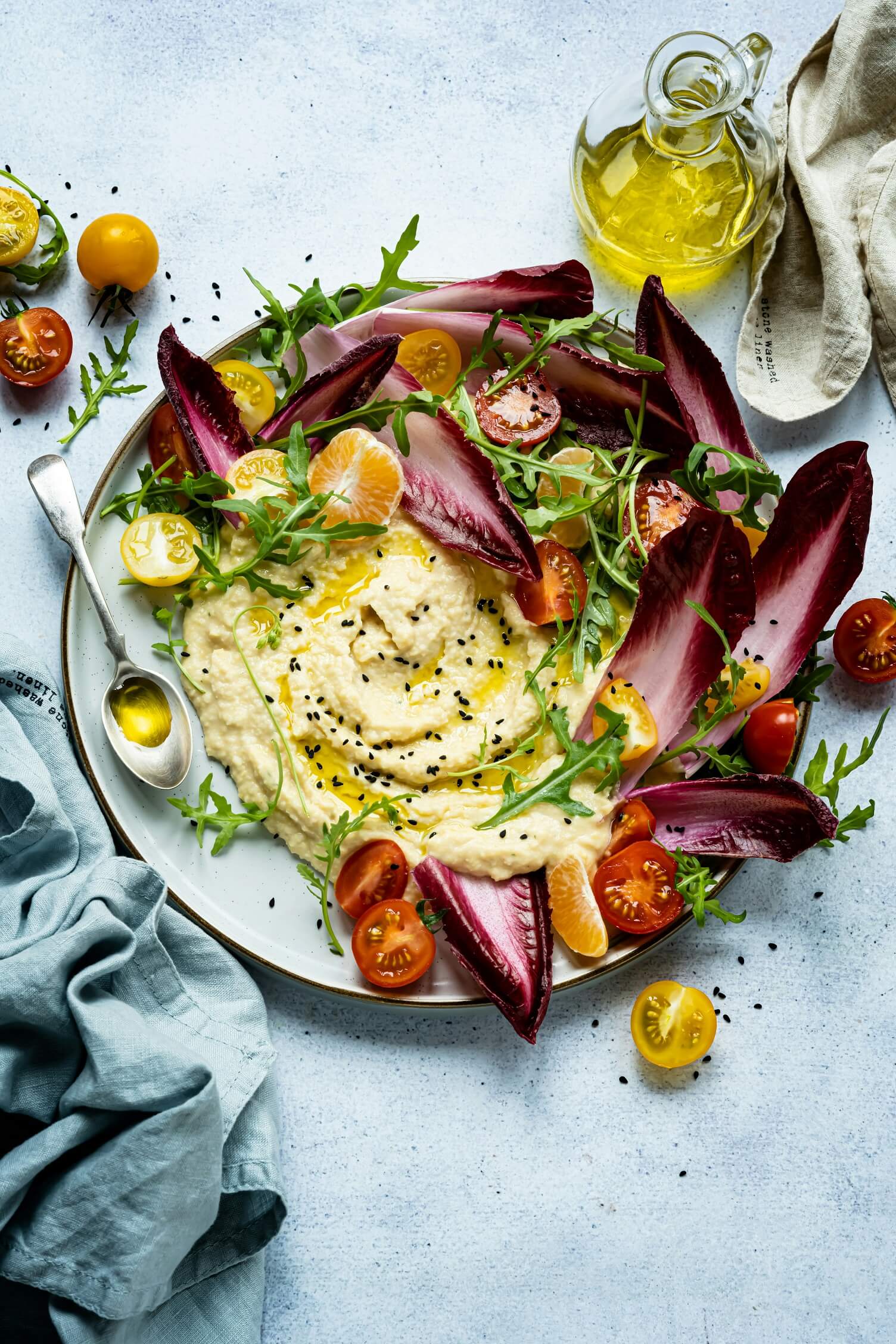 Gemüseplatte mit Hummus, Tomaten, Ruccola und Radicchio.