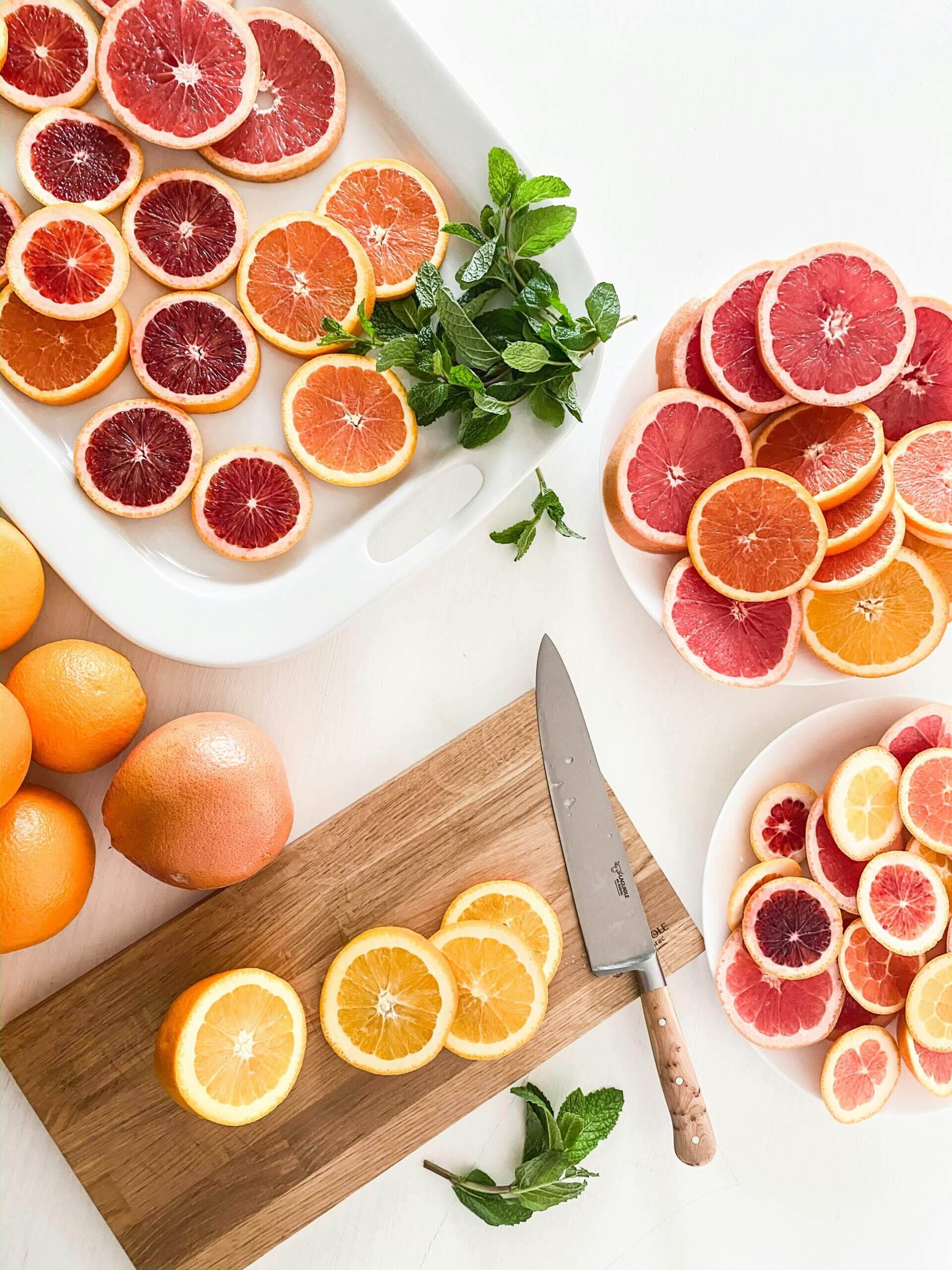 Ganze und in Scheiben geschnittene Orangen und Blutorangen.