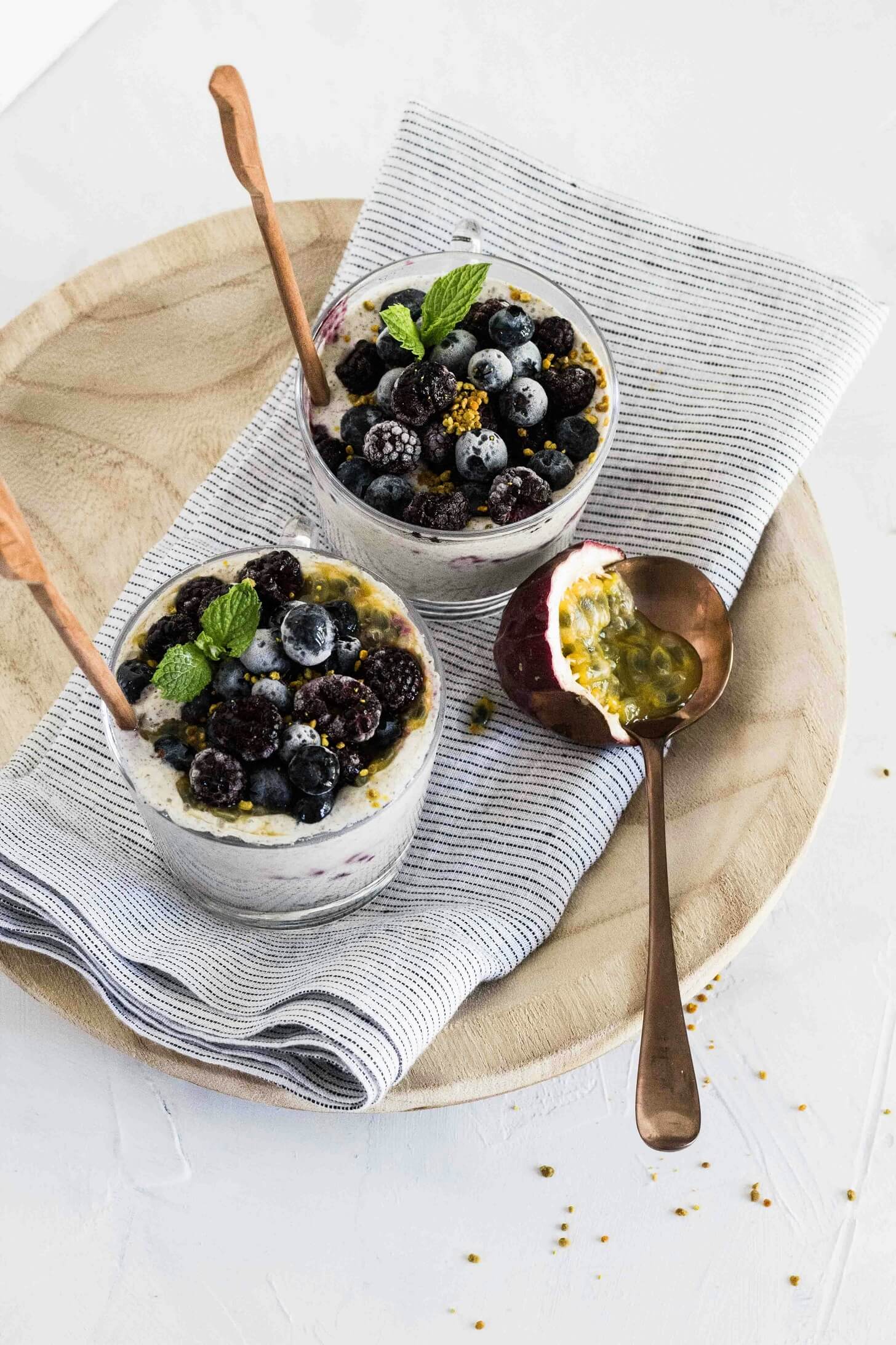 Veganes Joghurt mit Brombeeren und Heidelbeeren garniert mit frischer Minze und Passionsfrucht.